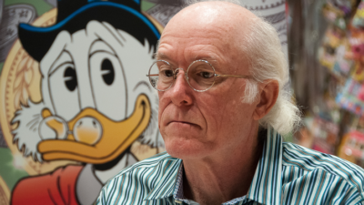 Tecknaren Don Rosa sitter framför en bild av Joakim von Anka