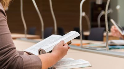 En elev sitter och läser i en bok