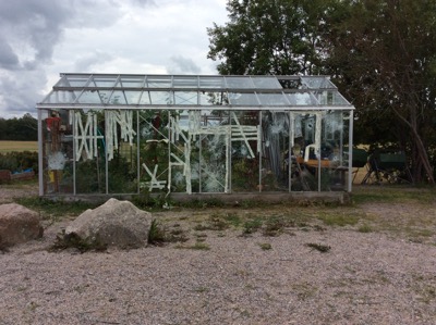 Bild på växthus med krossade rutor.