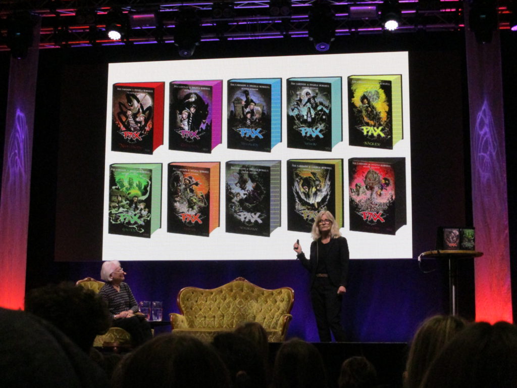 De 10 PAX-böckerna på en skärm som Ingela står framför och berättar om dem.