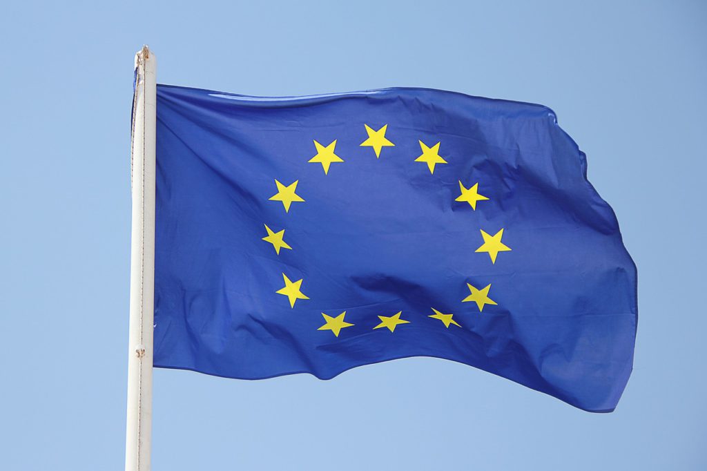 En EU-flagga är fäst på en flaggstång och vajar i vinden.