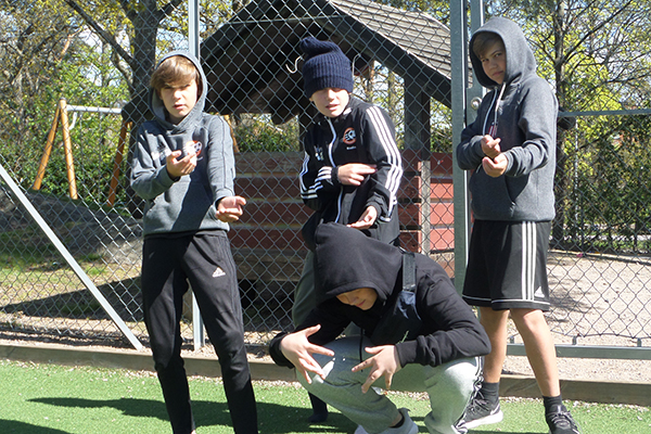 Fyra killar poserar på en fotbollsplan.