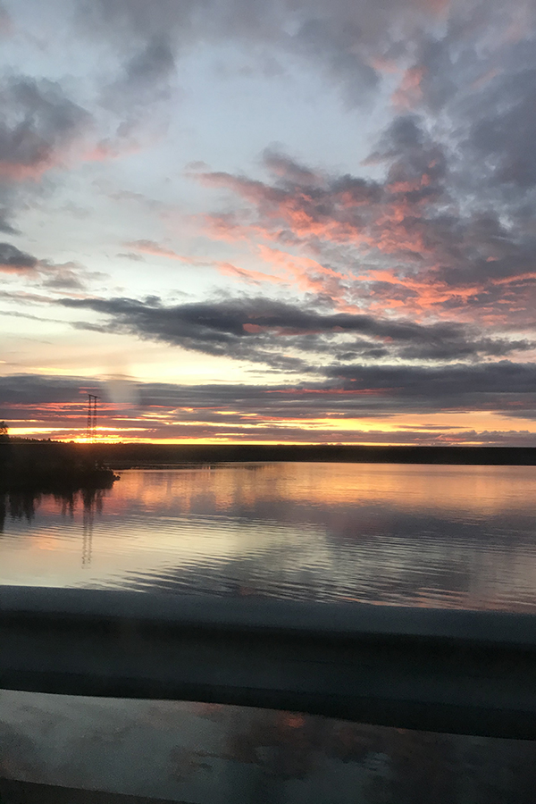 Solnedgång och spegelblankt vatten.