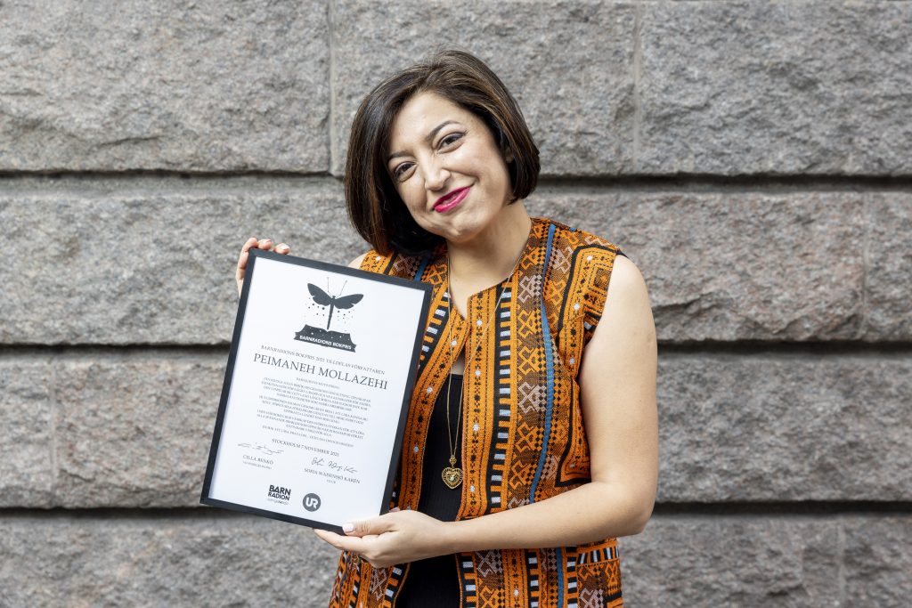 Peimaneh Mollazehi håller i sin bok ”Den riktiga solen”
