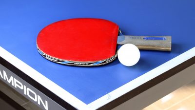 Bordtennisrack och boll på ett bord